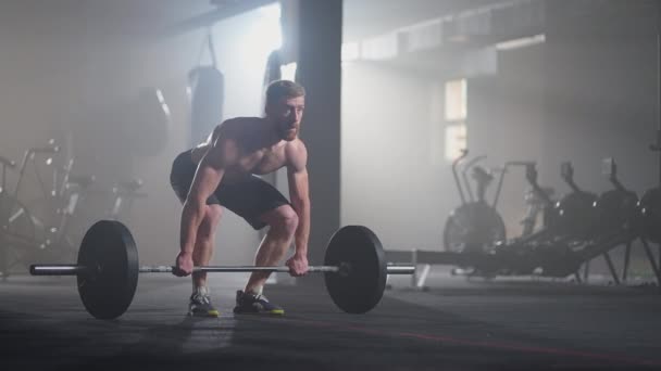 Cámara lenta: levantador de pesas masculino que se prepara para el entrenamiento en el gimnasio. Hombre gritando levantando pesas - Metraje, vídeo