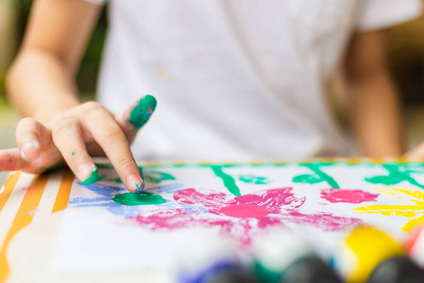 Kid pöydässä piirtää vesiväri, iloinen pieni söpö tyttö pelaa ja oppia väritys värejä - Valokuva, kuva