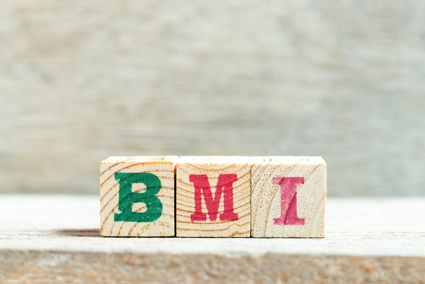 Blok liter alfabetu w słowie BMI (skrót od indeksu masy ciała) na tle drewna - Zdjęcie, obraz