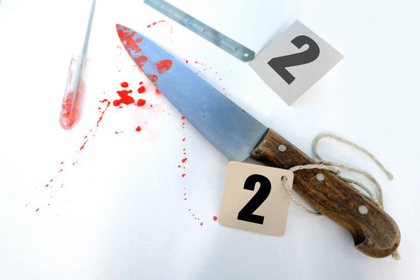 evidence idfresh splatter of red blood on white table, sharp knife stained at crime scene, entification markers, forensic medical examiner work concept - Zdjęcie, obraz