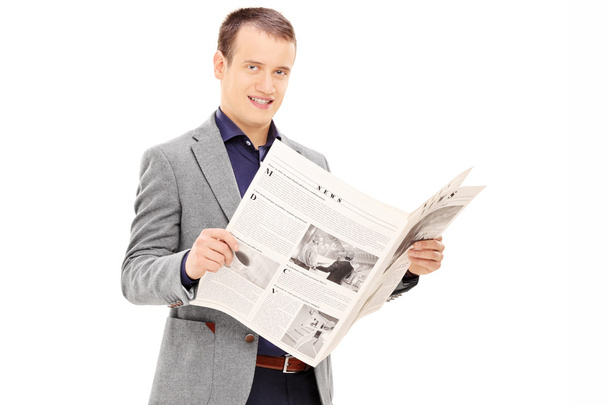 Young man holding newspaper - Fotó, kép