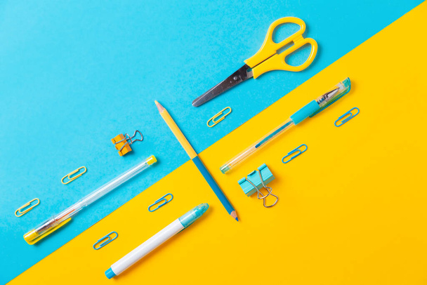 Blue and yellow office supplies on background. Flat lay. Back to school. Education and bussines concept. - Foto, Imagem