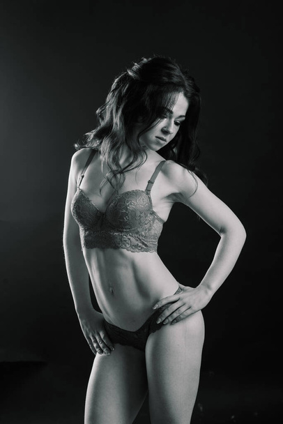 Krásná atletická žena třese břišními svaly na pozadí studia - Fotografie, Obrázek