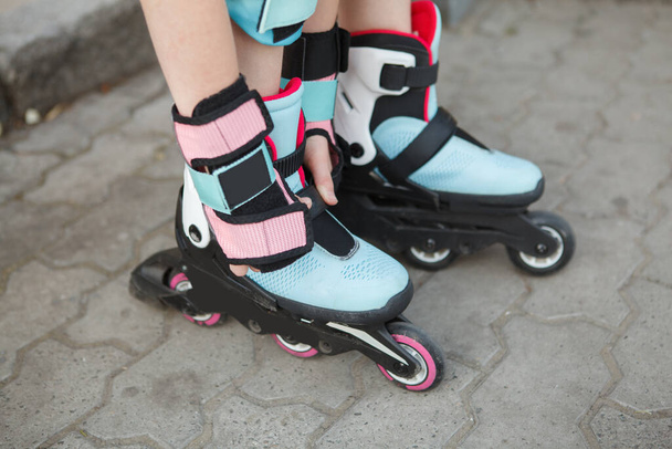 Unrecognizable child putting on rollerblades outdoors - Zdjęcie, obraz