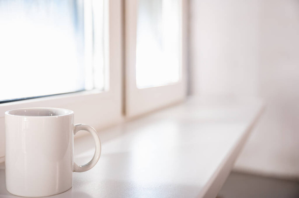 white porcelain coffee cup on the windowsill summer morning - Fotó, kép
