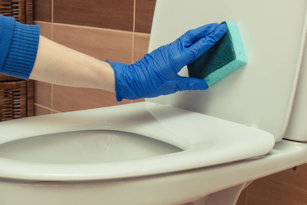 Hand of cleaner using brush for cleaning toilet in bathroom. Household duties concept - Foto, imagen