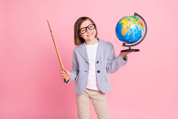 Portrait of attractive trendy cheerful girl holding stick globe lecture country map isolated over pink pastel color background - Foto, afbeelding