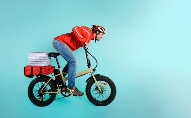 Deliveryman corre rápido con bicicleta eléctrica para entregar pizza - Foto, imagen