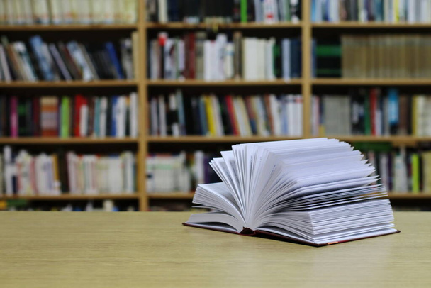 Открытая книга на столе в библиотеке - Фото, изображение