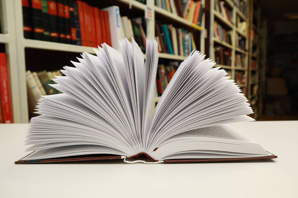 Открытая книга на столе в библиотеке - Фото, изображение