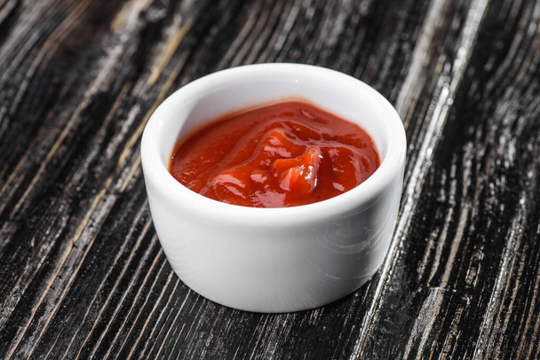 Koyu ahşap arka planda sos kabında kırmızı sos. Barbekü sosu - Fotoğraf, Görsel