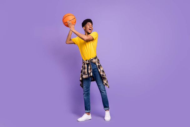Full size photo of happy afro american young man look empty space hold ball isolated on purple color background - Φωτογραφία, εικόνα