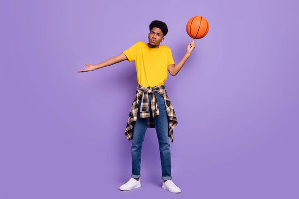 Full size photo of unhappy afro american young clueless man hold ball spin isolated on violet color background - Фото, зображення
