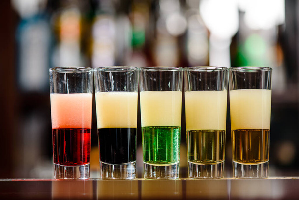 Красочные коктейли в баре. Сильные алкогольные напитки и текила - Фото, изображение