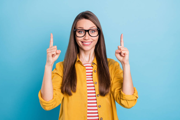 Photo of young woman happy positive smile point finger empty space direct way promo choose ad isolated over blue color background - Fotoğraf, Görsel