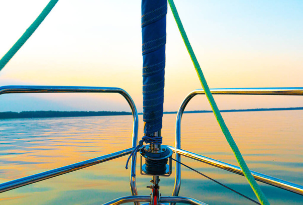 Barca a vela sul mare, un uomo su un bellissimo tramonto dorato - Foto, immagini
