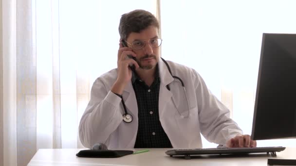Médico de seguros atendendo um telefonema em seu escritório - Filmagem, Vídeo