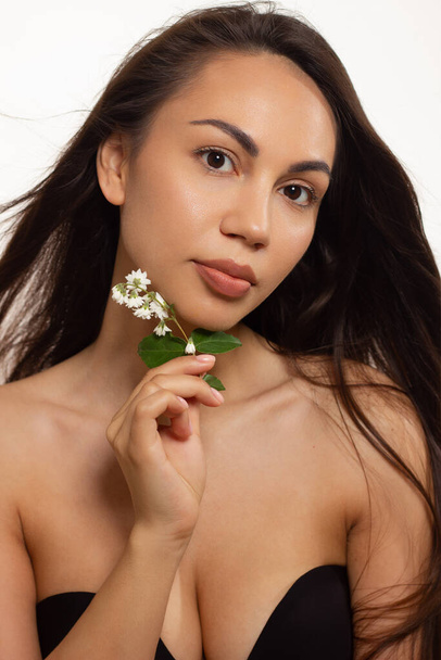 Closeup portrait of a woman with developing straight hair. Sweet tender young girl brunet. Natural lipstick, transparent clean skin. Skin care natural cosmetics in the spa salon or cosmetology. - Φωτογραφία, εικόνα