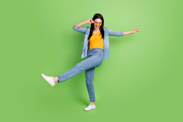 Full size photo of happy cheerful pretty lovely woman in sunglass silly dancing isolated on green color background - Fotografie, Obrázek
