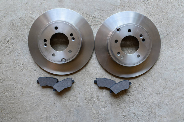 On the gray concrete floor there are brake discs and brake pads.Copy space - Photo, Image