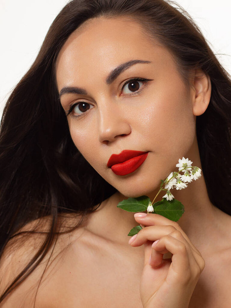 Close-up beauty of half female face withevening make-up. Black arrows on the eyes and extremely long eyelashes, on full red lips matte scarlet lip color. Well-groomed skin. Smile and white teeth - 写真・画像