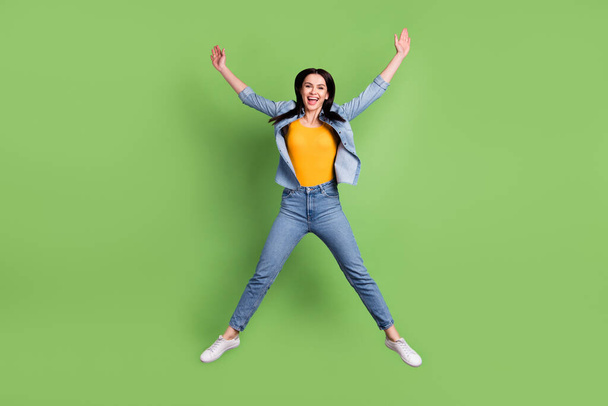 Full size photo of funny nice brown hairdo lady jump wear jeans shirt isolated on pastel green color background - Fotó, kép
