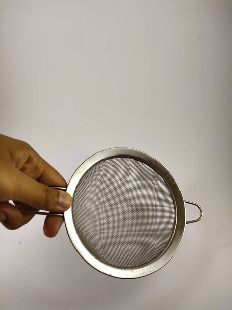 fénykép egy kéz kezében egy rozsdamentes acél színező elszigetelt fehér alapon - Fotó, kép