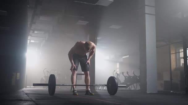 スローモーション:男性のパワーリフターはジムでのトレーニングの準備をします。重量を持ち上げる男を叫ぶ - 映像、動画