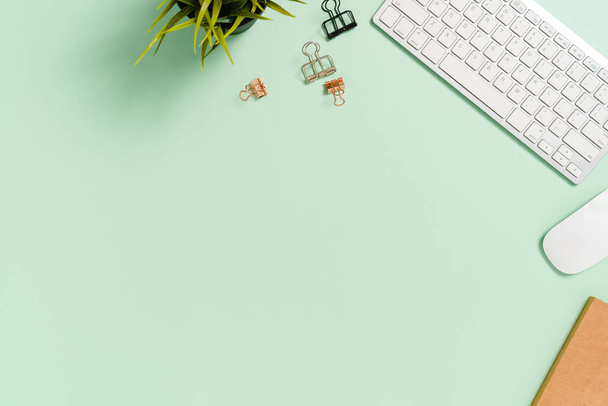 Espaço mínimo de trabalho - Creative flat lay photo of workspace desk. Mesa de escritório vista superior com teclado, mouse e livro em fundo de cor verde pastel. Vista superior com espaço de cópia, fotografia flat lay. - Foto, Imagem