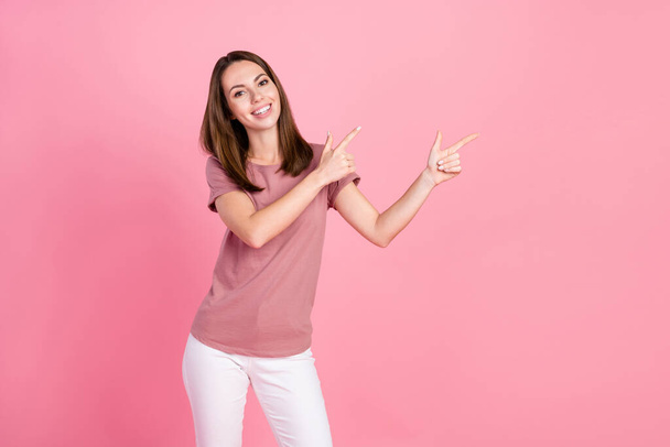 Portrait of attractive cheerful girl demonstrating copy blank space ad advert isolated over pink pastel color background - Foto, afbeelding