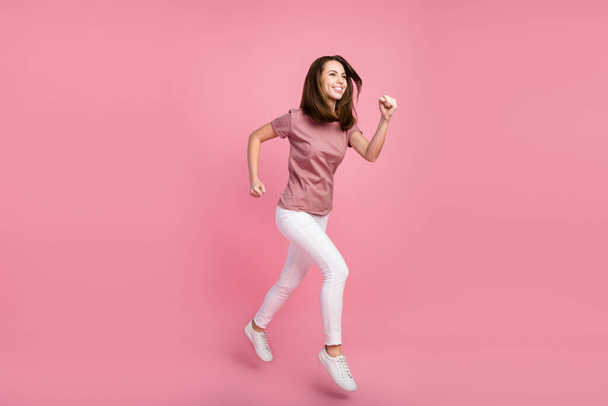 Full length body size view of attractive cheerful girl jumping running marathon isolated over pink pastel color background - Fotografie, Obrázek