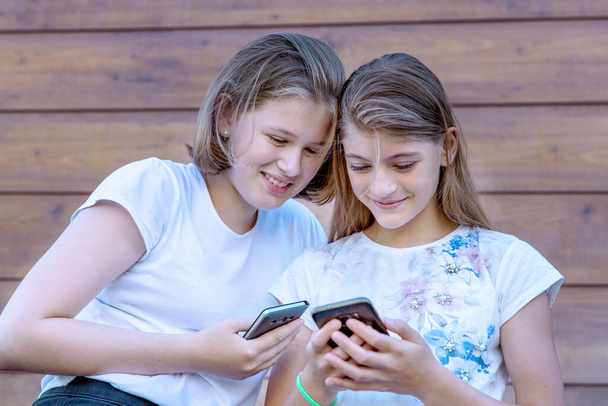 Két tinédzser lány élvezi az üzenetváltást a közösségi oldalakon. - Fotó, kép