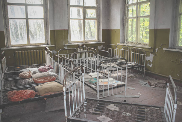 Empty Kindergarten Building. Baby cots arranged in disarray. Abandoned building in Pripyat - Fotoğraf, Görsel