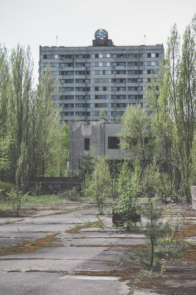 Verdund gebouw met het wapen van de USSR op het dak. Verlaten gebouw in spookstad Pripyat - Foto, afbeelding