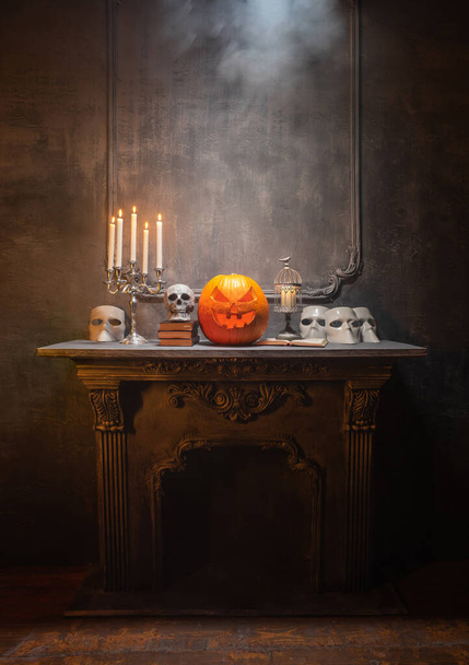 Scary laughing pumpkin and old skull on ancient gothic fireplace. Halloween, witchcraft and magic. - Φωτογραφία, εικόνα