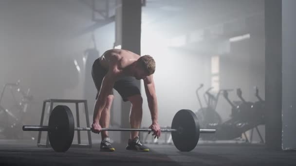 Zeitlupe: Männlicher Powerlifter bereitet sich auf das Training im Fitnessstudio vor. Schreiender Mann stemmt Gewichte - Filmmaterial, Video