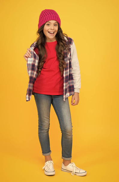 hip and stylish. teenager wearing casual style clothes. happy childhood. hipster look. cheerful child in knitted hat. denim fashion style. school girl on yellow background. kid fashion and beauty - Foto, Imagem