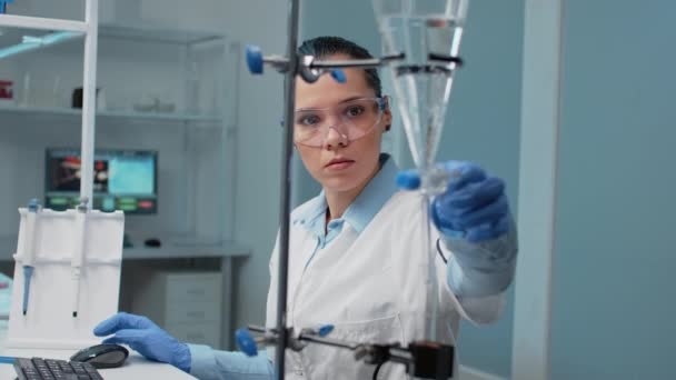 Médico de bioquímica con tubo de ensayo químico en laboratorio - Imágenes, Vídeo