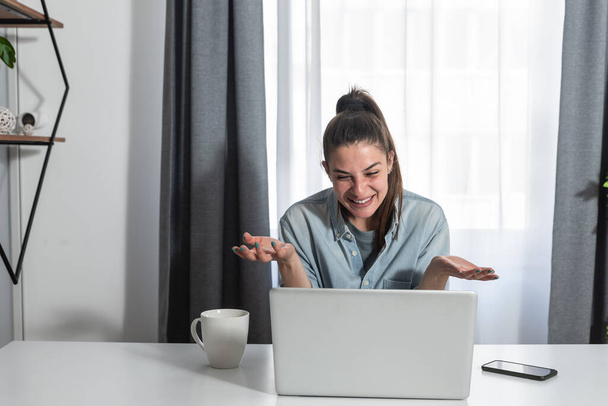 Young freelancer business woman having funny and relaxing conversation with client over video call on her laptop, business concept - 写真・画像