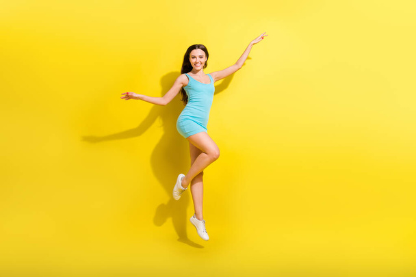 Full length photo of joyful brunette hairdo young lady jump wear teal dress isolated on vivid yellow color background - Foto, afbeelding