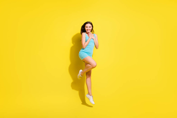 Full size photo of impressed brunette hairdo young lady jump wear teal dress isolated on vivid yellow color background - Photo, Image