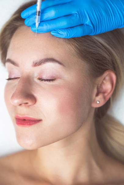 Procedimiento de inyecciones faciales rejuvenecedoras para apretar y alisar las arrugas en la piel de la cara - Foto, imagen