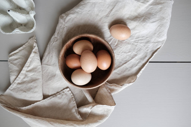 A top view of fresh brown eggs on a piece of cloth - Fotó, kép
