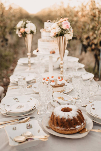 An elegant wedding table decorated with roses outdoors - Foto, immagini