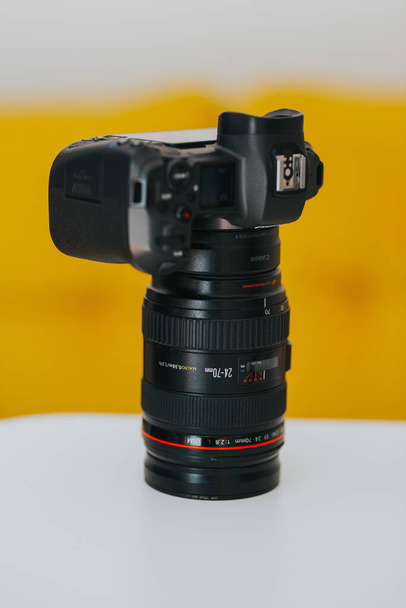BRCKO DISTRICT, BOSNIA AND HERZEGOVINA - Jul 08, 2021: A vertical closeup of Canon EOS R with Canon EF 24-70mm f2.8 lens on white table. - Foto, Bild