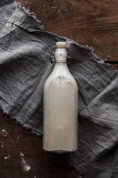 A top view shot of a bottle of milk on a wooden table - Fotó, kép
