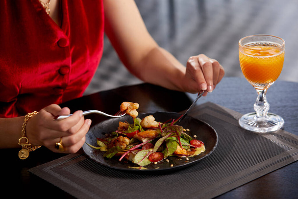豪華なレストランで昼食のための新鮮なサラダを食べる女性の作物ビュー,健康的なライフスタイル,食事のコンセプト - 写真・画像