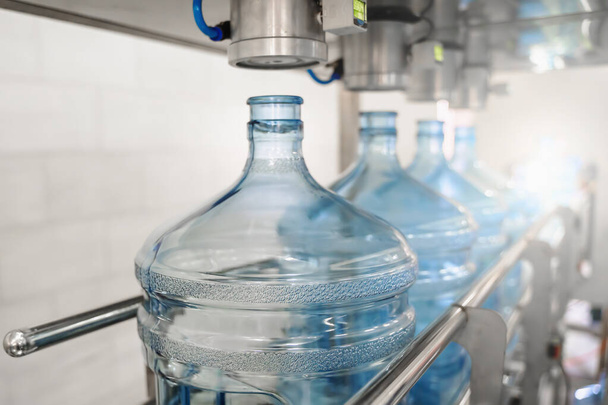 Proceso de producción fabricación de agua potable purificada y envasado en botellas de plástico en fábrica de bebidas, industria alimentaria, cinta transportadora - Foto, imagen