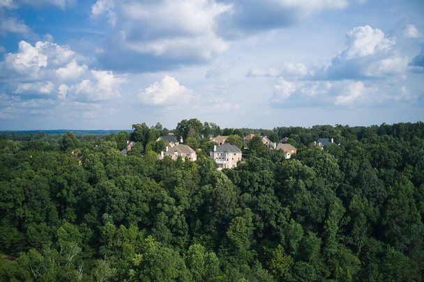 Воздушный панорамный вид на дом кластера и пышные зеленые деревья в подразделении в пригороде с полем для гольфа и озером в метро Атланта в штате Джорджия, США, снятый дроном в прекрасный летний день - Фото, изображение