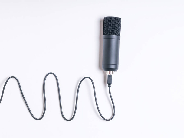 A modern condenser microphone with a wire on a white background. Sound recording equipment. - Photo, Image